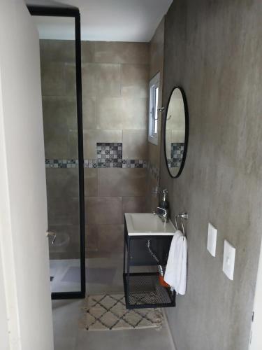 ein Badezimmer mit Waschbecken, Spiegel und Dusche in der Unterkunft Complejo El Caldén in Merlo