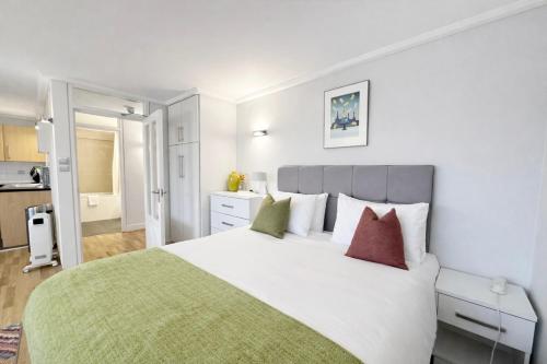 a bedroom with a large white bed with colorful pillows at Camden Serviced Apartments by Globe Apartments in London