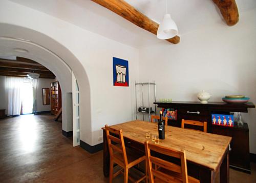 een eetkamer met een houten tafel en stoelen bij Asino Nero in Milis