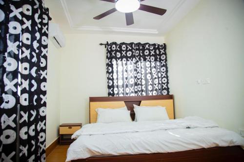 ein Schlafzimmer mit einem Bett mit Deckenventilator in der Unterkunft Georgina's Court in Trofwi