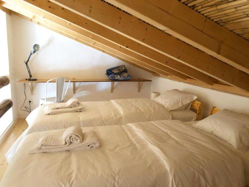 2 posti letto in camera con asciugamani di Casa Poente - Casas de Seixe a São Teotónio