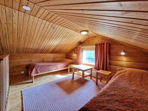 a room with two beds in a log cabin at Pääsiäiskuru 3 in Kakslauttanen