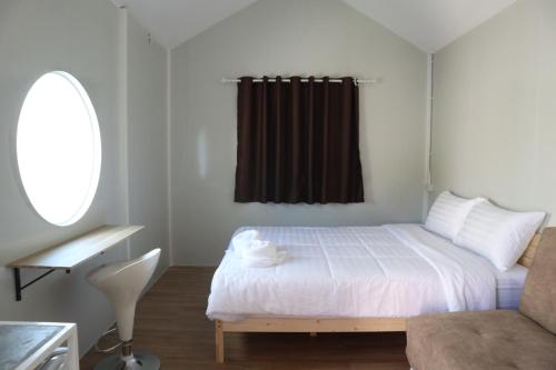 een kleine slaapkamer met een bed en een raam bij JAYLA Resort in Sattahip