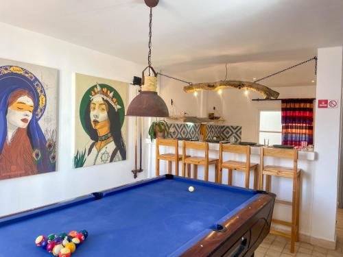 een woonkamer met een biljarttafel en schilderijen bij Taouarguit Guest House in Imsouane