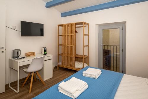 een kamer met een bed, een bureau en een computer bij Guest House - Appusentu in Castelsardo