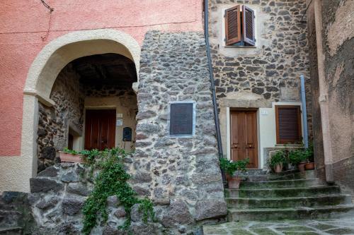 een stenen gebouw met een trap die naar twee ingangen leidt bij Guest House - Appusentu in Castelsardo