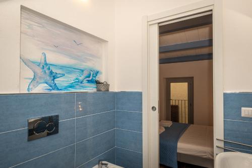 a bathroom with a painting of a shark on the wall at Guest House - Appusentu in Castelsardo
