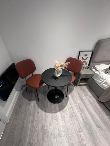 a room with a table and two chairs and a bed at Exclusive, newly built detached garden studio, private and self-contained, within family home grounds in Swanscombe