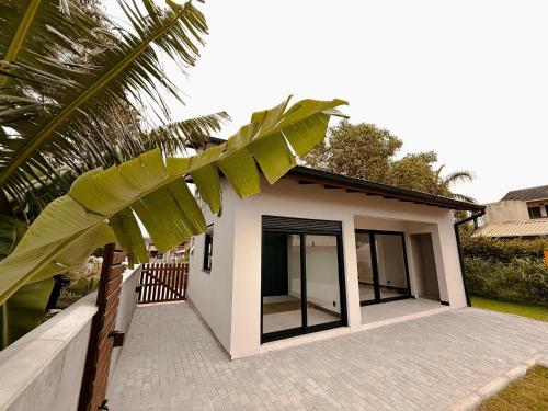 una piccola casa con porte a vetri e una palma di Vila do Sol a Florianópolis