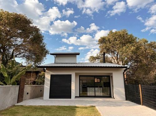 una piccola casa bianca con garage di Vila do Sol a Florianópolis