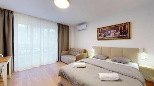 a bedroom with a large bed and a couch at NEW Studio by Nivy & Bus Station w AC in Bratislava