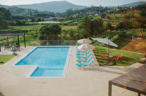 ein Swimmingpool mit Stühlen und Sonnenschirmen neben in der Unterkunft Sandoco House - Golf Adventure in Arcozelo