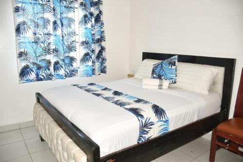 a bedroom with a bed with a blue and white blanket at Buxton-Point Furnished Apartment in Mombasa