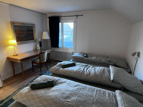 a bedroom with two beds and a desk and a window at Apartment Spiez - Lake view - for 7 guests in Thun