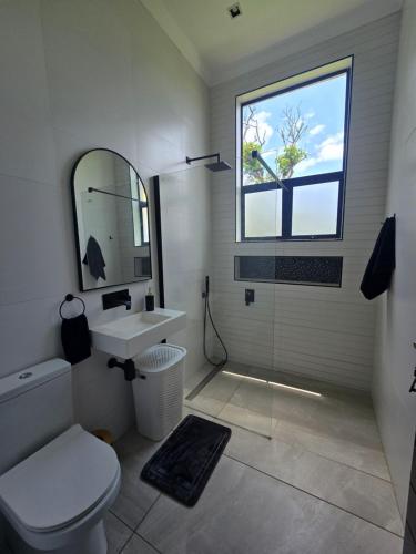 een badkamer met toilet, wastafel en raam bij Maja Hzari in Densainagar