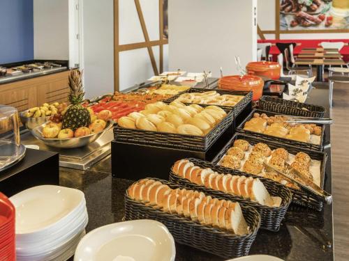 ein Buffet mit vielen Tabletts mit verschiedenen Arten von Speisen in der Unterkunft ibis Igrejinha in Igrejinha