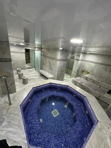 a large blue swimming pool in a room with stairs at Hotel Mounia in Fès
