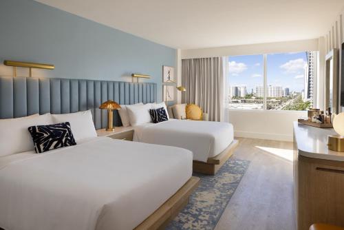 een hotelkamer met twee bedden en een raam bij The Sunny in Sunny Isles Beach