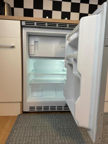 an empty refrigerator with its door open in a kitchen at Studio apartment - Park view - for 2 guests in Thun