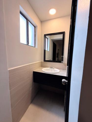 a bathroom with a sink and a mirror at Hotel Señorial in Matamoros