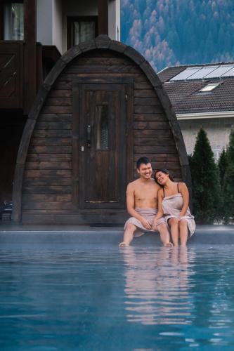 a man and a woman sitting in the water at Aria Life Hotel Pinzolo in Pinzolo