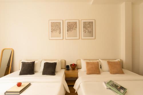 two beds sitting next to each other in a room at The Hammond Saigon in Ho Chi Minh City