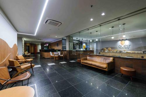 a lobby with a restaurant with a couch and chairs at Vitoria Praia Hotel in Vitória