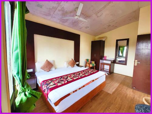 una camera da letto con un letto grande in una stanza di Hotel Saanidhya Blue Moon Palace Inn Near Bhimtal Lake- Wifi - Room Service - Parking Facilities - Velly view Hotel a Nainital