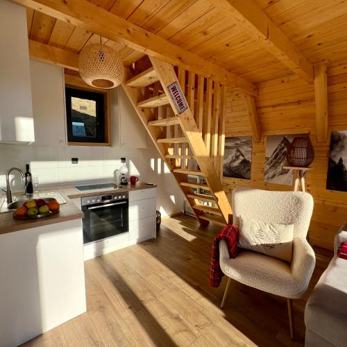 a kitchen with a staircase in a wooden house at Vikendica Nomadova Koliba in Tvrdimići