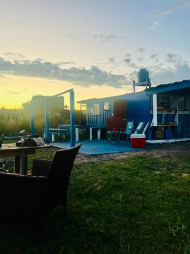 a house with a table and chairs in the grass at El Antiguo Hostel in Cabo Polonio