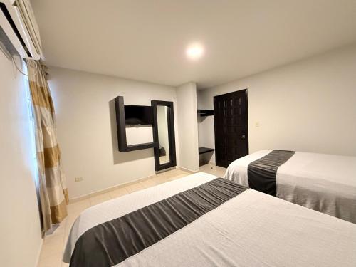 a hotel room with two beds and a window at Hotel Señorial in Matamoros