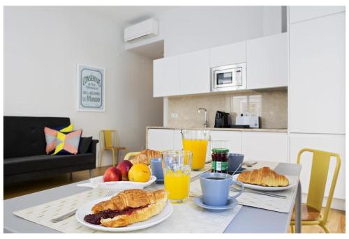 einen Tisch mit Speisen und Orangensaft in der Unterkunft Residencial Neves - Baixa in Lissabon