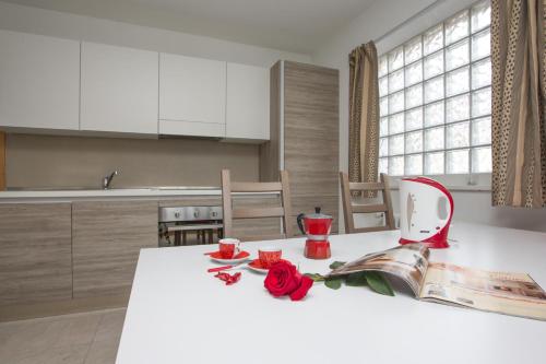 a kitchen with a table with a book and roses on it at Casa Smith e Bice in Bormio