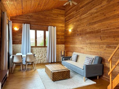 een woonkamer met een bank en een tafel bij Duplex Chalet style private yard 150m to RER in Bagneux