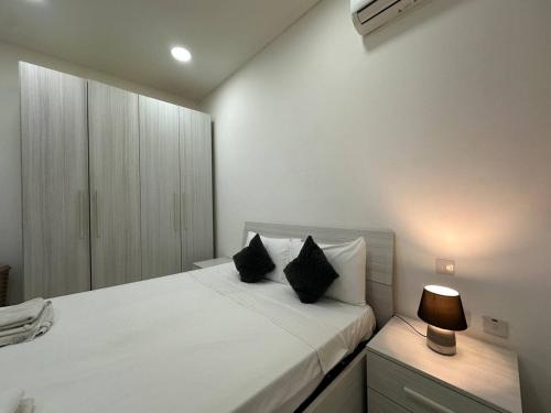 una camera da letto con un grande letto bianco con due cuscini di Central Oasis with Private Pool and Lounge Area a Msida
