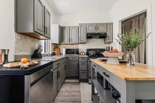 a kitchen with gray cabinets and a wooden counter top at The Caleb Loft near Manhattan with NYC skyline view in Hoboken
