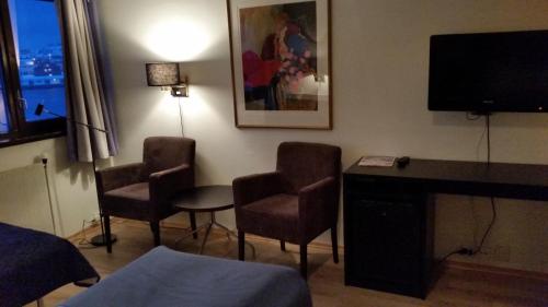 a hotel room with two chairs and a desk and a television at Vardø Hotel in Vardø