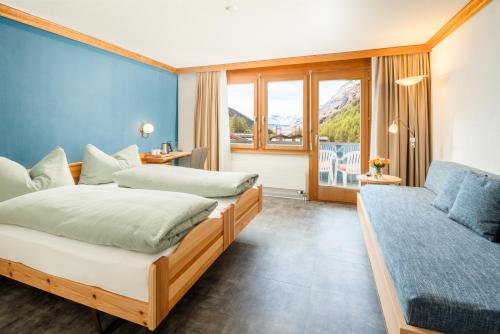een hotelkamer met twee bedden en een raam bij Ski-In/Ski-Out Hotel Sport in Saas-Almagell