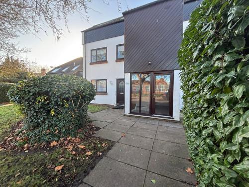 een wit huis met een zwart dak bij Canal Side Retreat in Heybridge