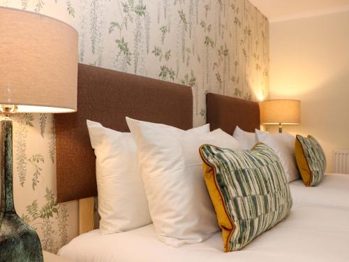 een slaapkamer met een bed met witte kussens bij Paye House - Cromarty in Cromarty