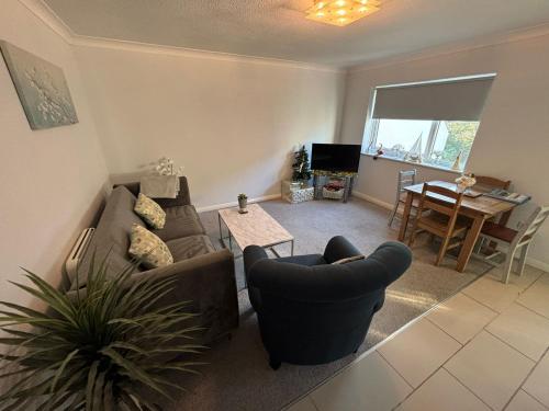 a living room with a couch and chairs and a table at Canal Side Retreat in Maldon