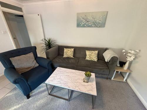 a living room with a couch and a coffee table at Canal Side Retreat in Maldon