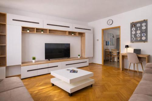 un soggiorno con una TV a schermo piatto su una parete di Comfort 14 Stylish City Apartment a Miskolc