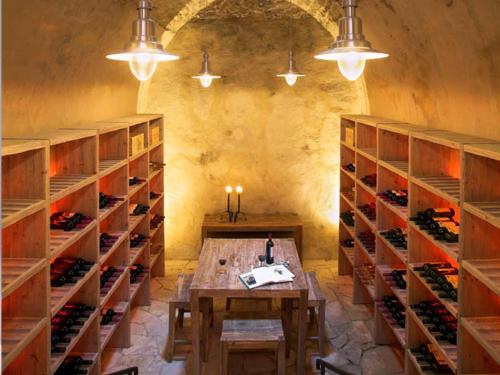 a wine cellar with a wooden table and shelves of wine bottles at Apokryfo Traditional Guesthouse in Lofou