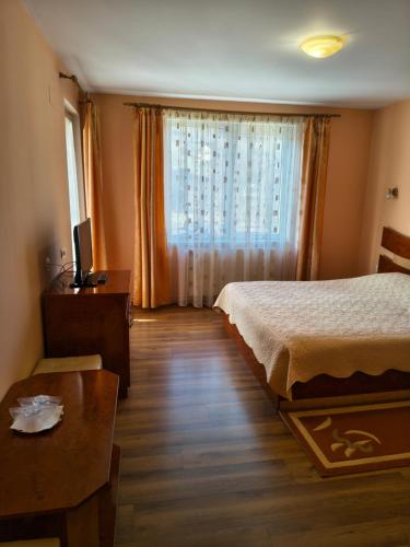 ein Schlafzimmer mit einem Bett und einem Tisch und einem Fenster in der Unterkunft LaBrazi in Şimon