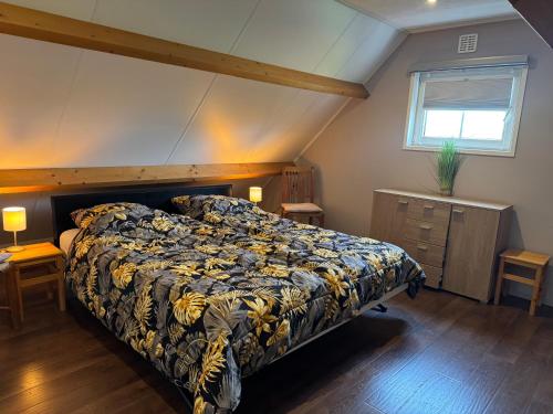 een slaapkamer met een bed, twee tafels en een raam bij Beachloft Zeeland 1 in Scharendijke