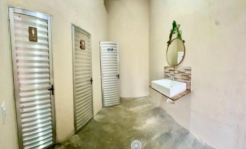 a bathroom with a toilet and a sink and a mirror at Chácara Ana Clara in Cotia