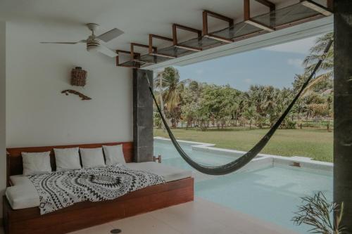 a bedroom with a hammock and a swimming pool at Stunning Ocean Front By Condo Boutique in Playa del Carmen