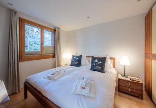 a bedroom with a large bed with towels on it at Chalet Waldschluecht in Wengen