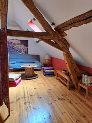 een woonkamer met een blauwe bank en een tafel bij La Petite Longère in Talcy